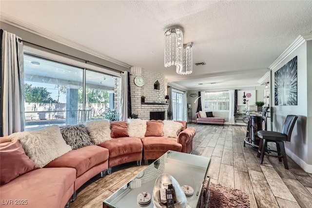 living room featuring a healthy amount of sunlight, visible vents, ornamental molding, and wood finished floors