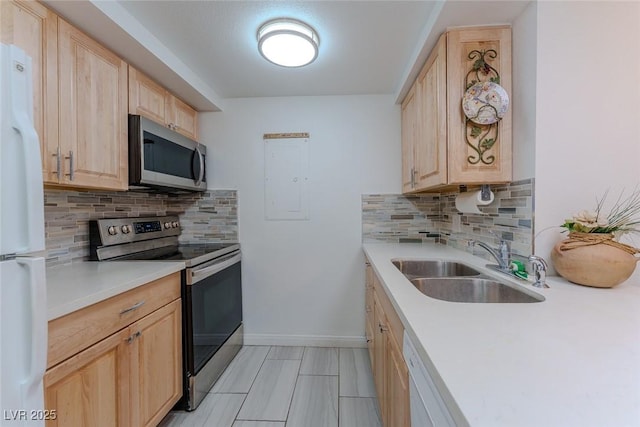 kitchen featuring stainless steel appliances, light brown cabinetry, sink, and decorative backsplash