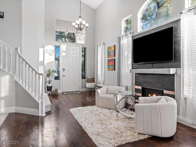 entrance foyer with dark wood-type flooring, high vaulted ceiling, and a chandelier