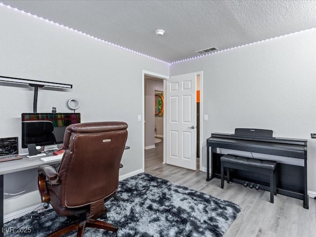 office space featuring a textured ceiling and light hardwood / wood-style flooring