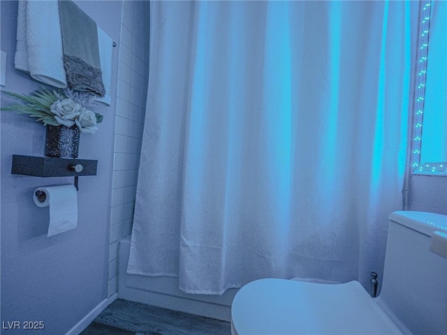 bathroom featuring shower / bath combo with shower curtain and toilet