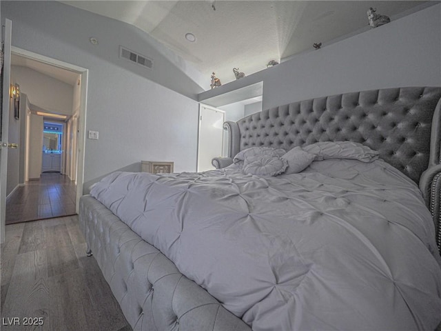 bedroom with lofted ceiling and hardwood / wood-style flooring