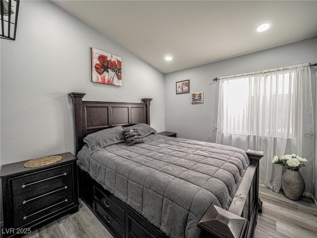 bedroom featuring vaulted ceiling and light wood-type flooring