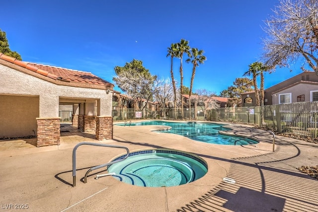 view of swimming pool featuring a patio area and a hot tub