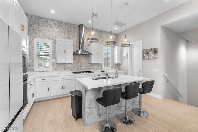 2503 Cracked Stone St, Henderson, NV 89044 - kitchen with a center island with sink, light countertops, white cabinets, a sink, and wall chimney exhaust hood