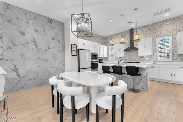 2503 Cracked Stone St, Henderson, NV 89044 - kitchen with stainless steel appliances, white cabinets, light countertops, and wall chimney exhaust hood