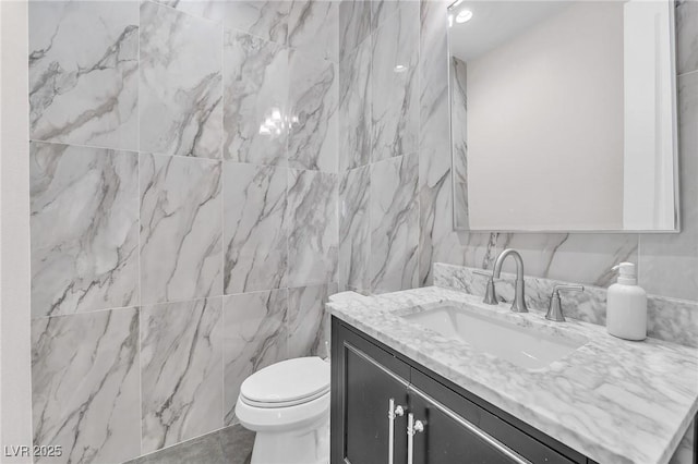 2503 Cracked Stone St, Henderson, NV 89044 - bathroom with toilet, tile walls, and vanity