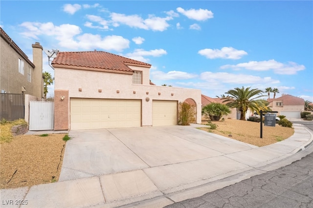 mediterranean / spanish-style home with fence, a tiled roof, stucco siding, driveway, and an attached garage