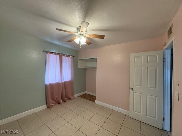 unfurnished bedroom with light tile patterned flooring, ceiling fan, a closet, and a textured ceiling