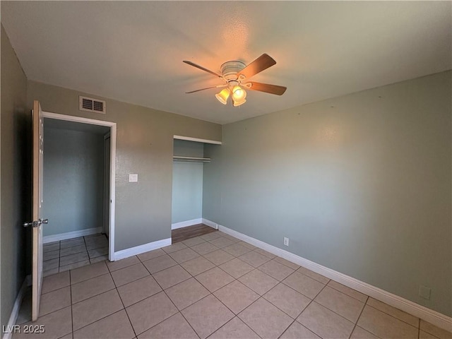 unfurnished bedroom with light tile patterned floors, ceiling fan, and a closet