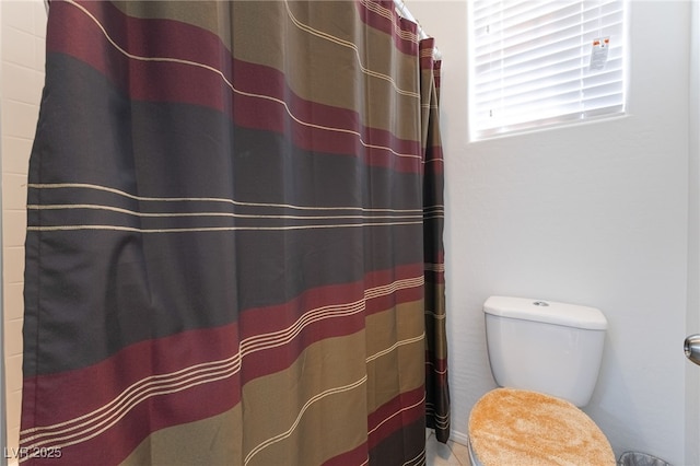 bathroom featuring toilet and a shower with curtain