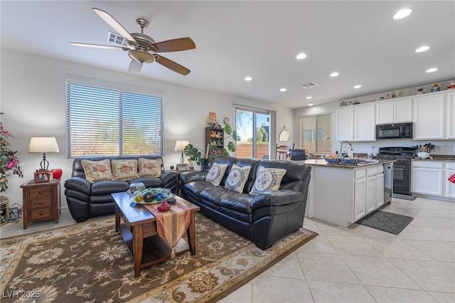 tiled living room featuring ceiling fan and sink