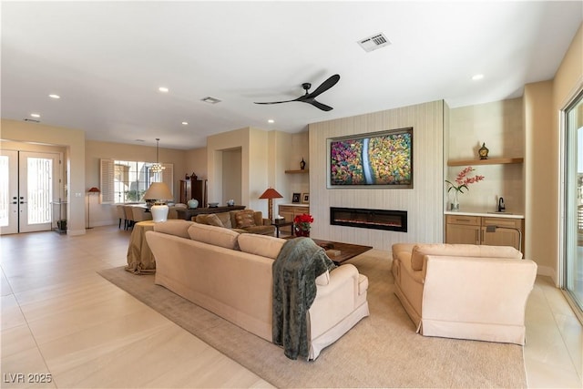 4796 Riva De Romanza St, Las Vegas, NV 89135 - living area featuring a glass covered fireplace, a ceiling fan, recessed lighting, and light tile patterned flooring