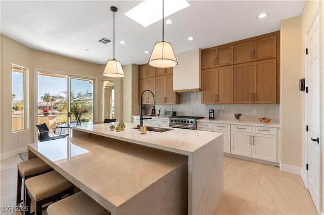 4796 Riva De Romanza St, Las Vegas, NV 89135 - kitchen featuring stainless steel stove, recessed lighting, backsplash, a kitchen island with sink, and light tile patterned flooring