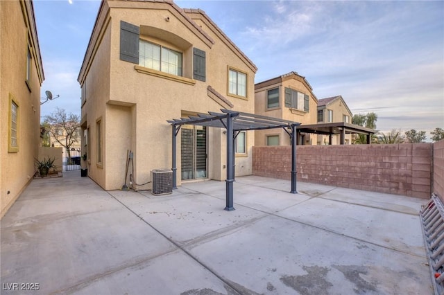 rear view of property featuring cooling unit, a pergola, and a patio area