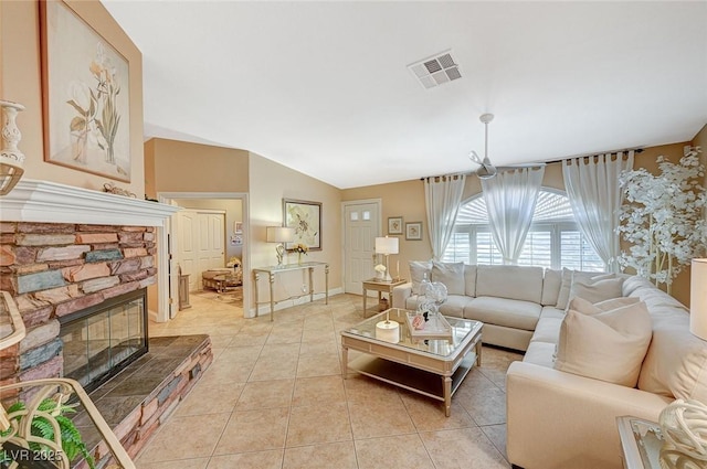 living room with a fireplace, vaulted ceiling, and light tile patterned flooring