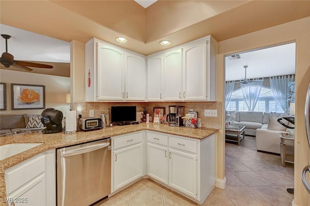 kitchen with white cabinetry, backsplash, stainless steel dishwasher, and light tile patterned floors