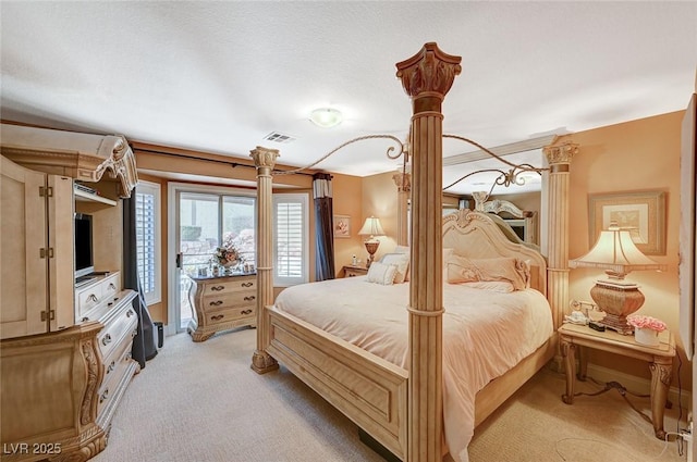 carpeted bedroom with decorative columns and access to exterior