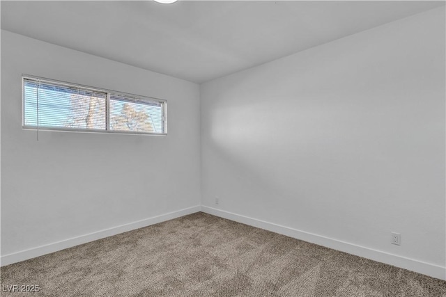 carpeted spare room featuring baseboards