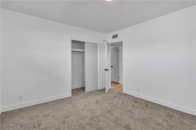 unfurnished bedroom with baseboards, a closet, visible vents, and light colored carpet