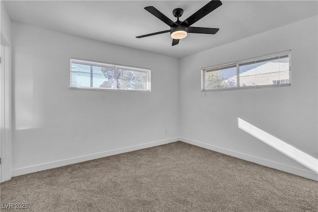 carpeted empty room with a ceiling fan, plenty of natural light, and baseboards