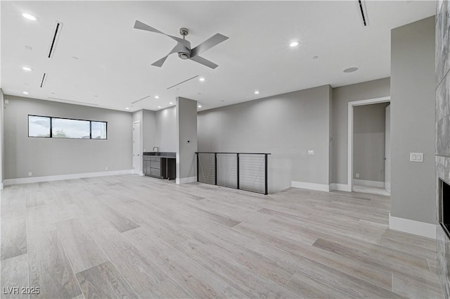 unfurnished living room with ceiling fan and light hardwood / wood-style floors