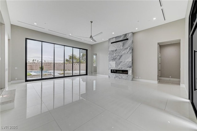 unfurnished living room featuring ceiling fan, a high end fireplace, and light tile patterned floors