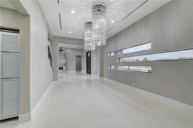 unfurnished room with an inviting chandelier and light tile patterned floors