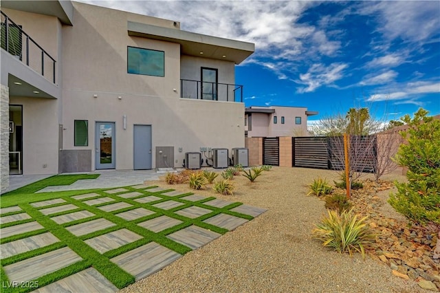 rear view of house with central AC unit and a patio