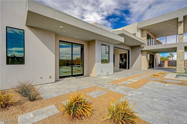 view of exterior entry with a patio