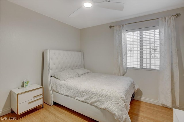 bedroom featuring light wood-style floors, baseboards, and a ceiling fan