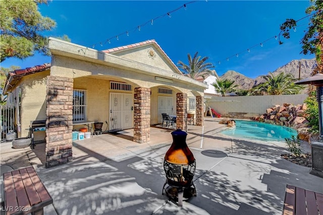exterior space with a tiled roof, stucco siding, a patio area, fence, and a fenced in pool