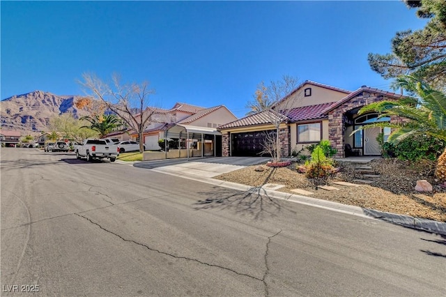 view of front of house featuring stucco siding, a mountain view, driveway, a garage, and a tiled roof