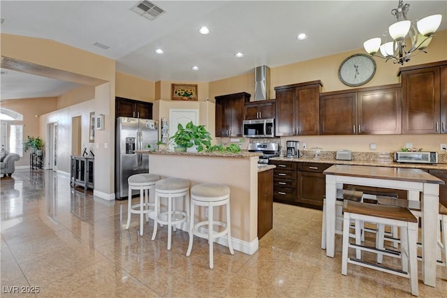 kitchen with visible vents, a center island, a notable chandelier, dark brown cabinetry, and stainless steel appliances
