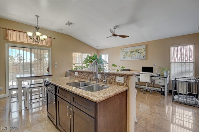 kitchen with vaulted ceiling, decorative light fixtures, visible vents, ceiling fan with notable chandelier, and a sink
