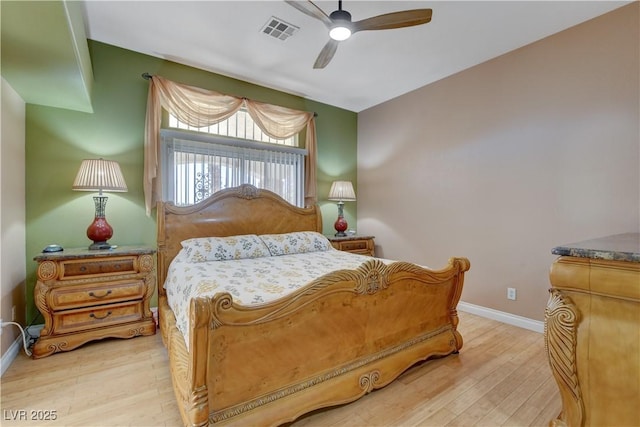 bedroom with wood finished floors, ceiling fan, baseboards, and visible vents