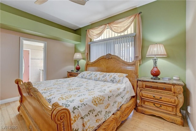 bedroom featuring baseboards, connected bathroom, and wood finished floors