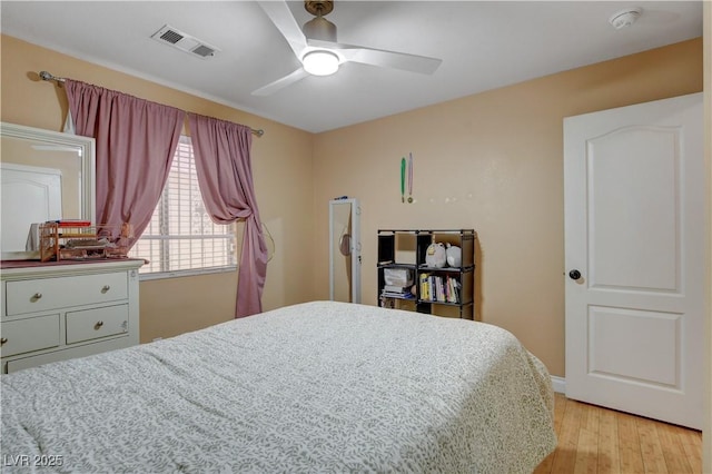 bedroom featuring light wood-type flooring, ceiling fan, and visible vents