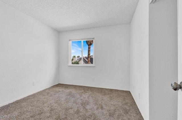 carpeted empty room featuring a textured ceiling