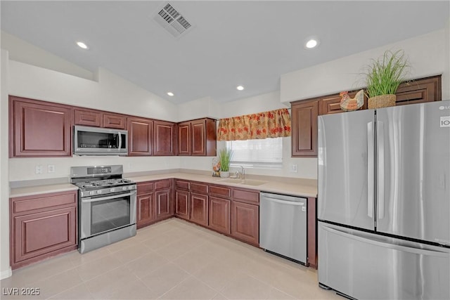 kitchen with sink, appliances with stainless steel finishes, and lofted ceiling