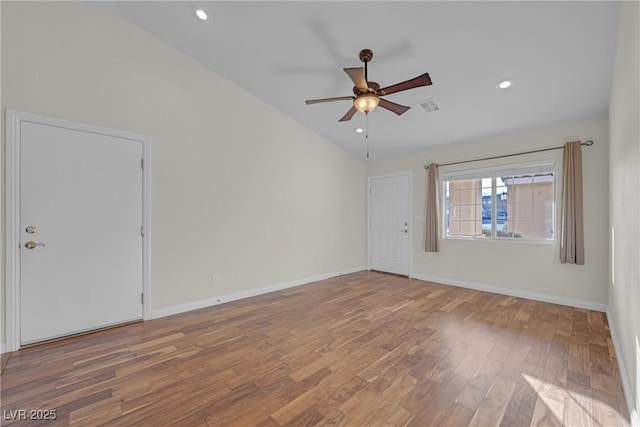 empty room with ceiling fan, lofted ceiling, and wood-type flooring