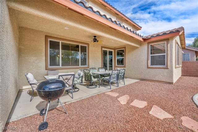 view of patio featuring outdoor dining space, a ceiling fan, and fence