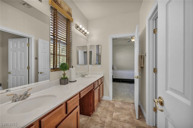 ensuite bathroom with double vanity, visible vents, tile patterned floors, and a sink