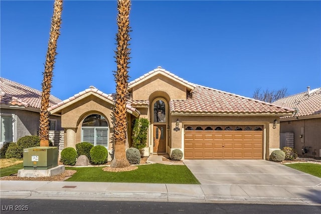 mediterranean / spanish house with stucco siding, a tile roof, and a garage