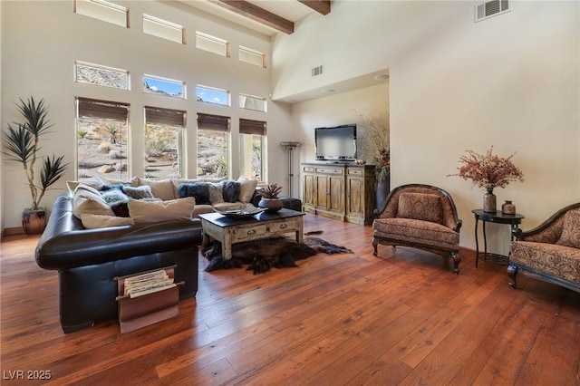 living room featuring dark wood-type flooring and beamed ceiling