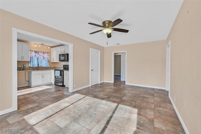 unfurnished living room with track lighting and ceiling fan