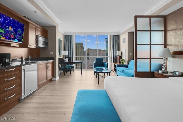 145 E Harmon Ave Unit 2603, Las Vegas, NV 89109 - bedroom with crown molding, light wood finished floors, a wall of windows, and a sink