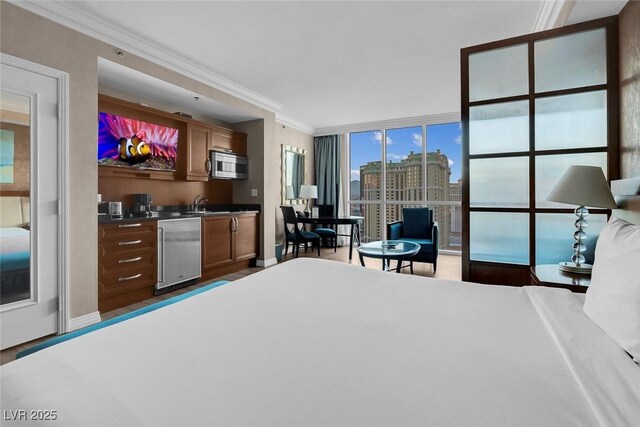 145 E Harmon Ave Unit 2603, Las Vegas, NV 89109 - bedroom with a wall of windows, wood finished floors, bar with sink, fridge, and crown molding