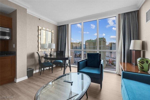 145 E Harmon Ave Unit 2603, Las Vegas, NV 89109 - living room featuring light wood finished floors, ornamental molding, baseboards, expansive windows, and a view of city