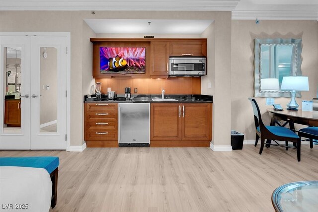 145 E Harmon Ave Unit 2603, Las Vegas, NV 89109 - indoor wet bar with stainless steel microwave, fridge, french doors, light wood-style flooring, and crown molding